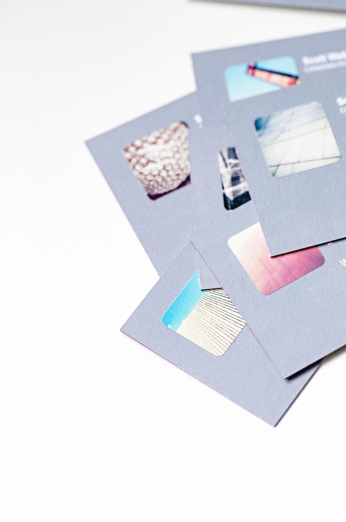 High-angle view of abstract business card designs with cutout details on a white background.